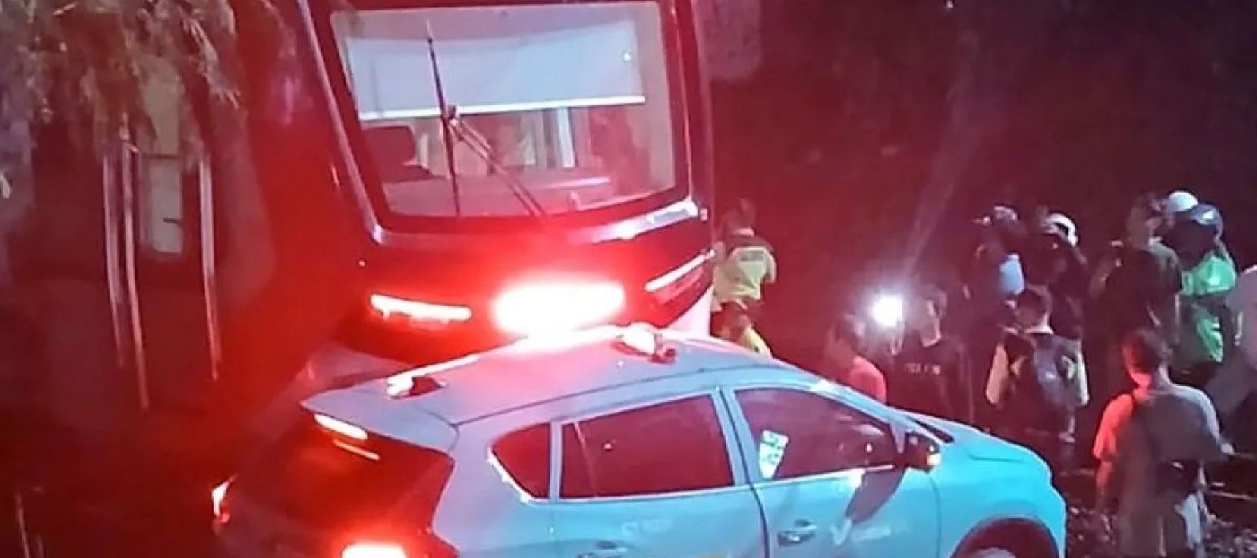 Warga melihat commuter line (KRL) jurusan Cikarang yang menabrak kendaraan roda empat yang mogok di perlintasan kereta api dekat stasiun Bekasi Timur, Jawa Barat.