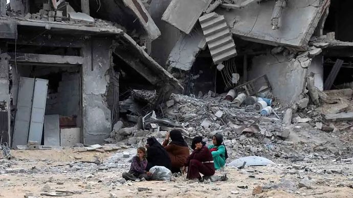 Arsip - Warga Palestina duduk di antara bangunan yang hancur saat kembali ke Khan Younis, Jalur Gaza, 12 Oktober 2025. Kesepakatan gencatan senjata antara Israel dan Hamas mulai berlaku pada 10 Oktober.