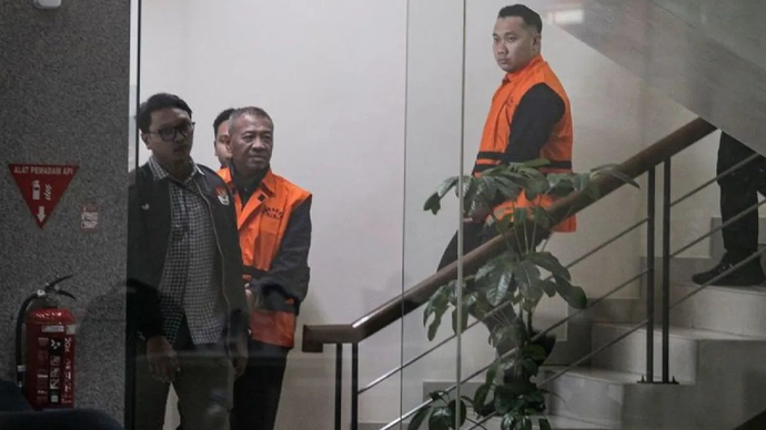 Bupati Tulungagung Gatut Sunu Wibowo (kedua kiri) bersama ajudannya Dwi Yoga Ambal (kanan) mengenakan rompi tahanan usai menjalani pemeriksaan setelah terjaring Operasi Tangkap Tangan (OTT) di Gedung Merah Putih KPK, Jakarta, Minggu (12/4/2026) dini hari. KPK menetapkan status tersangka dan menahan Bupati Tulungagung Gatut Sunu Wibowo (GSW) dan ajudannya Dwi Yoga Ambal dalam OTT terkait kasus pemerasan dan penerimaan lainnya di lingkungan Pemkab Tulungagung dengan mengamankan barang bukti uang tunai senilai Rp335,4 juta yang merupakan bagian dari uang senilai Rp2,7 miliar yang diduga telah diterima GSW dari permintaan sebesar Rp5 miliar. ANTARA FOTO/Darryl Ramadhan/nz/pri.