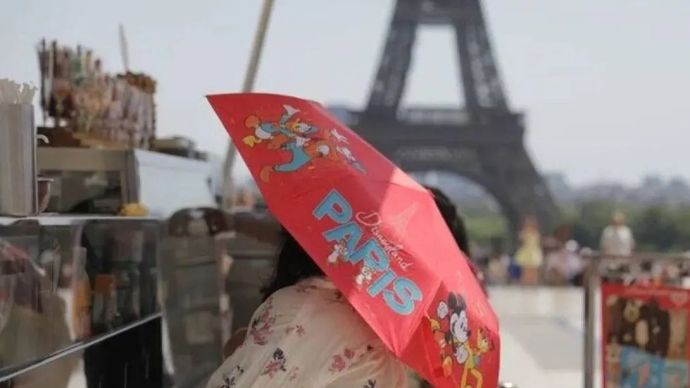 Orang-orang yang memegang payung berusaha melindungi diri dari terik matahari di dekat Menara Eiffel yang ikonik di Paris, Prancis, pada 2 Juli 2025. Negara-negara Eropa seperti Prancis, Spanyol, dan Italia pada hari Rabu terus dilanda gelombang panas yang memecahkan rekor, menghadapi suhu ekstrem, badai, kebakaran, bahkan kematian. 