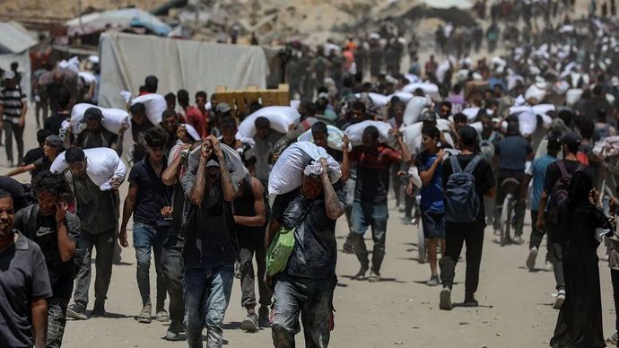 Warga membawa bantuan kemanusiaan di Beit Lahia, Jalur Gaza utara, Palestina. Selasa, 5 Agustus 2025.
