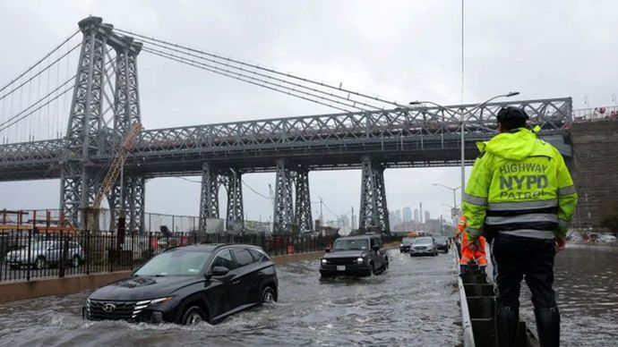 Arsip foto - Seorang polisi Patroli Jalan Raya NYPD mengamati para pengendara yang sedang menembus banjir di jalanan FDR Drive di Manhattan dekat jembatan Williamsburg di New York City, Amerika Serikat, pada Jumat, 1 Agustus 2025.