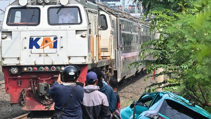 Kereta api (KA) jarak jauh melintas di samping taksi listrik Green SM yang rusak pascakecelakaan KRL Commuter Line dan KA Argo Bromo Anggrek di Stasiun Bekasi Timur, Bekasi, Jawa Barat, Selasa (28/4/2026). ANTARA FOTO/Fakhri Hermansyah/nz.