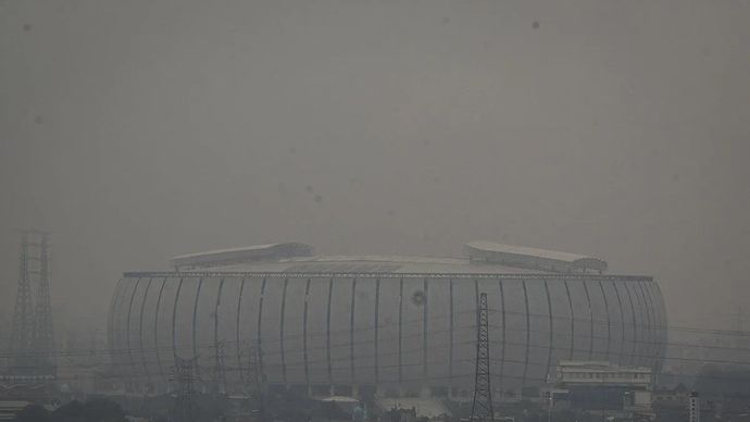 Suasana polusi udara yang menyelimuti bangunan Jakarta International Stadium (JIS), Jakarta Utara.