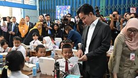 Wakil Presiden Gibran Rakabuming Raka menerima surat dari seorang murid saat meninjau pemberian makan siang bergizi di Sekolah Dasar Negeri (SDN) 03 Jakarta Pusat, Selasa.