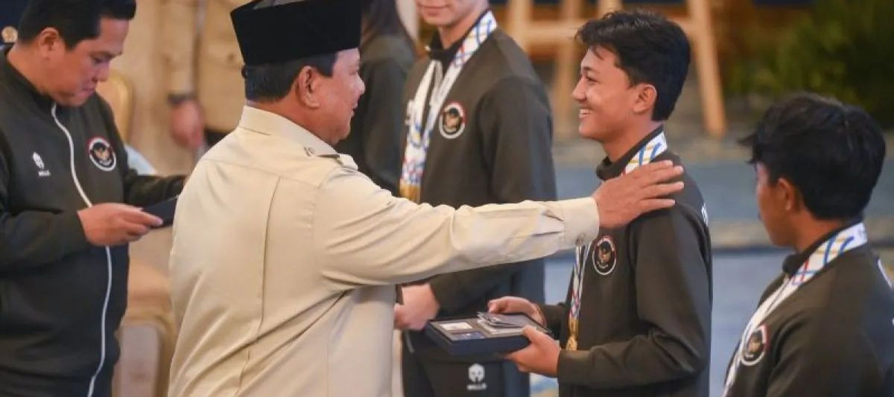 Presiden Prabowo Subianto (kedua kiri) didampingi Menpora Erick Thohir (kiri) menyerahkan buku tabungan kepada atlet skateboard Basral Graito (kedua kanan) saat penyerahan bonus kepada atlet peraih medali pada SEA Games Thailand di Istana Negara, Jak
