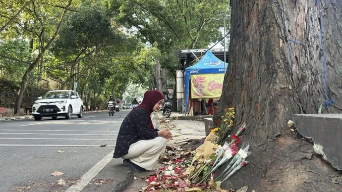 Salah seorang warga tengah ikut menabur bunga serta mendoakan almarhum Muhammad Fahdly Arjasubrata di lokasi kejadian perkara kasus pengeroyokan di Jalan Cihampelas, Kota Bandung, Jawa Barat, Mingu 15 Maret 2026. ANTARA/Rubby Jovan/pri.