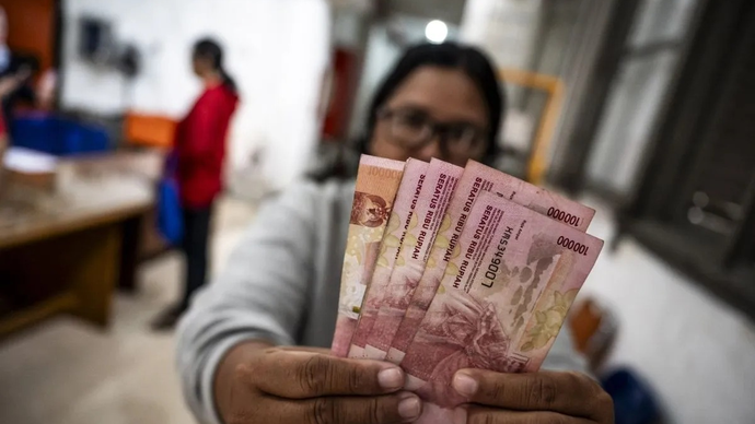 Arsip - Warga penerima manfaat menunjukkan uang tunai Bantuan Langsung Tunai (BLT) Kesejahteraan Rakyat (Kesra) tahap IV di Kantor Pos Besar, Semarang, Jawa Tengah, Rabu (31/12/2025). Pemerintah menyalurkan BLT Kesra tersebut sekaligus untuk tiga bulan yakni Oktober, November dan Desember 2025 dengan total bantuan sebesar Rp900 ribu yang diterima setiap Keluarga Penerima Manfaat (KPM). ANTARA FOTO/Aprillio Akbar/nym.