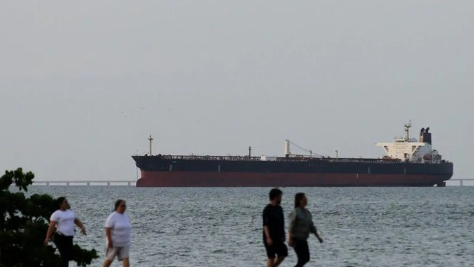 Arsip - Orang-orang sedang berolahraga dengan background sebuah kapal yang melewati Selat Hormuz. (ANTARA/Anadolu Agency/pri)