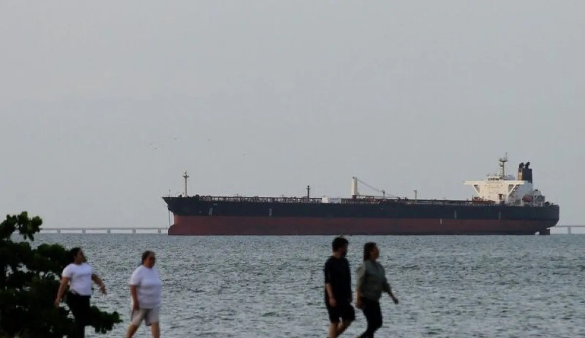 Arsip - Orang-orang sedang berolahraga dengan background sebuah kapal yang melewati Selat Hormuz. (ANTARA/Anadolu Agency/pri) <b>(Antara)</b>