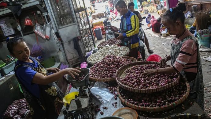 Pedagang menimbang bawang merah pesanan pembeli di Pasar MAJT, Semarang, Jawa Tengah.