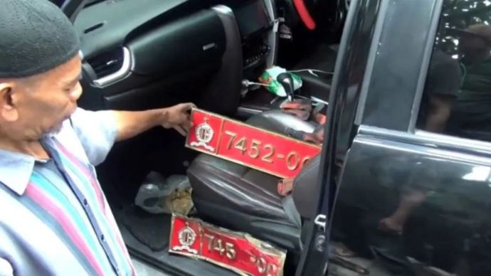 Saksi menunjukkan pelat merah pada kendaraan tabrakan beruntun di Jalan Ahmad Yani, tepatnya di depan Halte Transjakarta Utan Kayu, Jakarta Timur, Jumat, 11 Juli 2025.