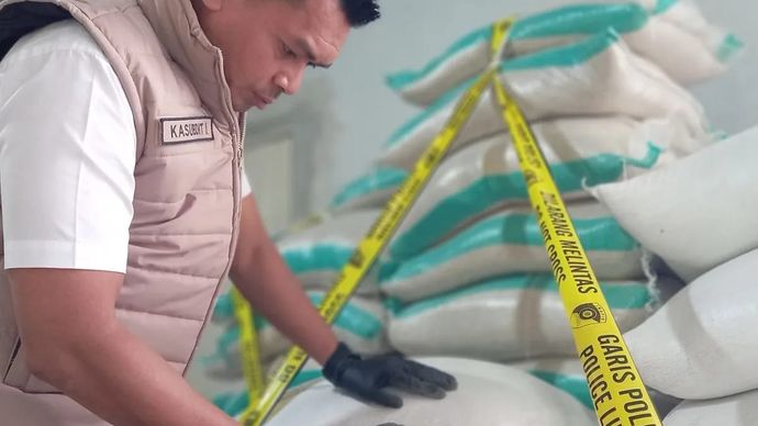 Anggota Satgas Pangan Polda NTB memeriksa tumpukan karung beras diduga oplosan yang terpasang garis polisi dalam giat penggerebekan di rumah yang menjadi gudang produksi dan penampungan milik ASN Lombok Tengah berinisial NA di BTN Pemda Dasan Geres, Lombok Barat, Rabu 30 Juli 2025. (ANTARA/HO-Polda NTB)
