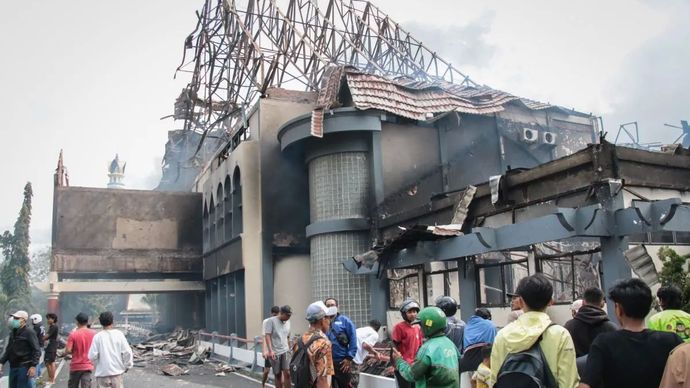 Warga menyaksikan sisa gedung DPRD NTB yang terbakar dalam aksi unjuk rasa di Mataram, Sabtu, 30 Agustus 2025.