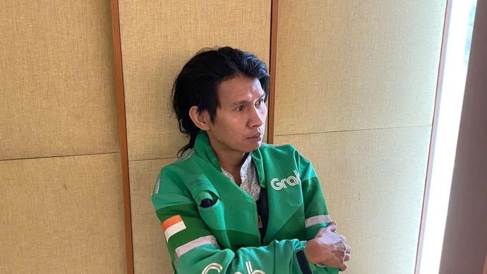 Tukang ojek daring bernama Zulkarnaen menunggu sang anak saat mengikuti masa pengenalan lingkungan sekolah (MPLS) untuk siswa Sekolah Rakyat Margaguna, Jakarta, Senin, 14 Juli 2025.