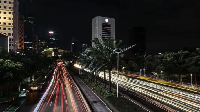 Sejumlah kendaraan melintas saat pemadaman lampu penerangan jalan di Jalan Jenderal Sudirman, Jakarta.