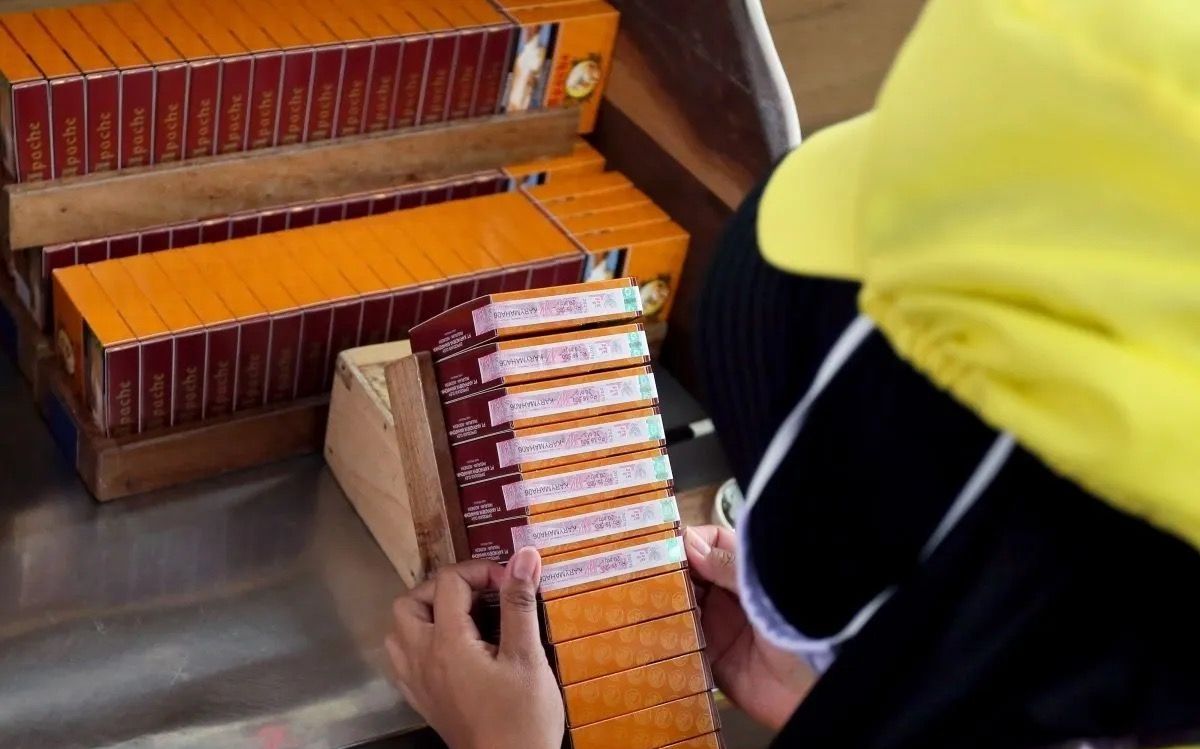 Buruh linting rokok menempel pita cukai di salah satu pabrik rokok di Blitar, Jawa Timur. <b>(Antara)</b>