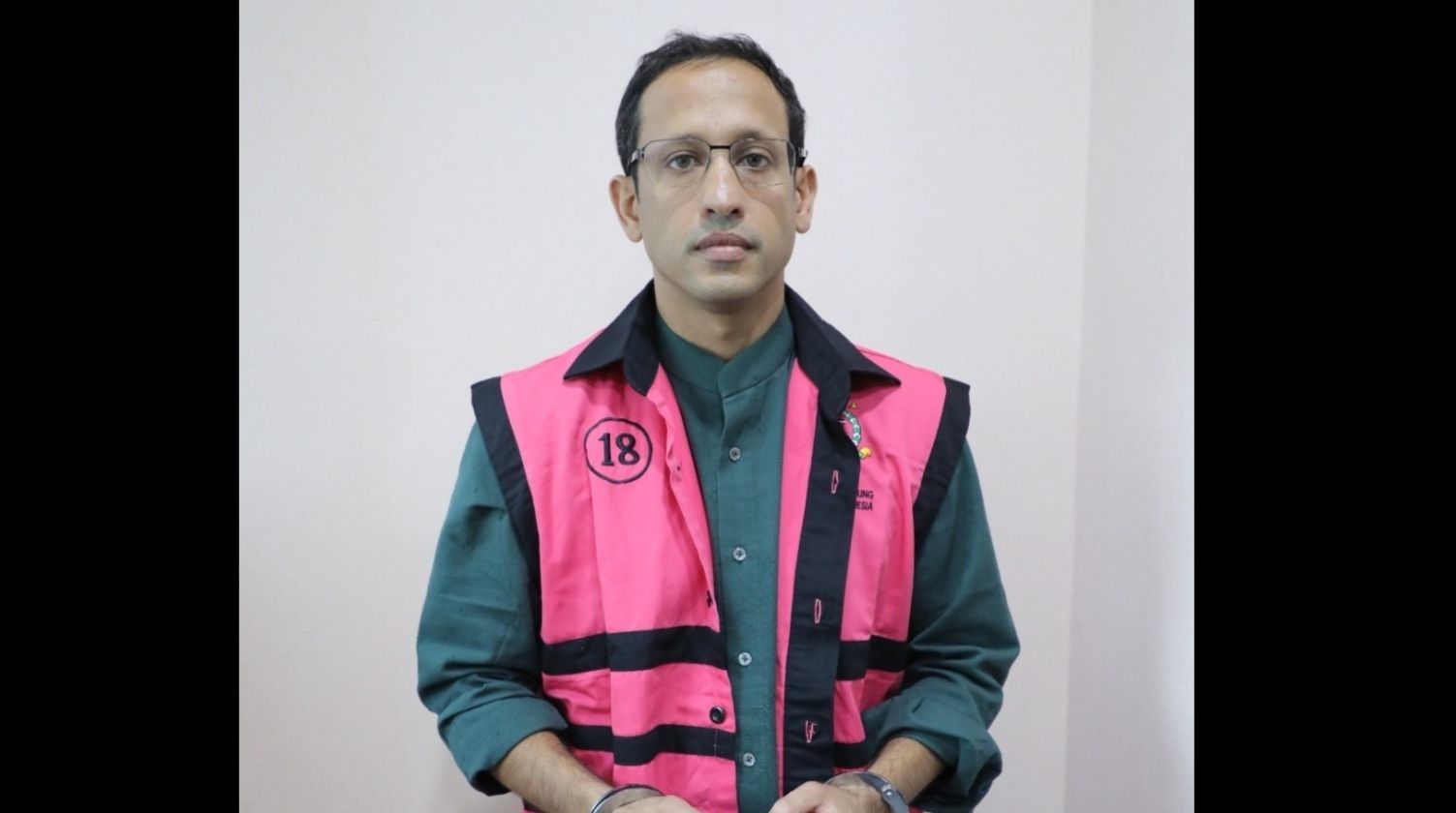 Nadiem Makarim saat mengenakan rompi pink dan kedua tangannya diborgol. 