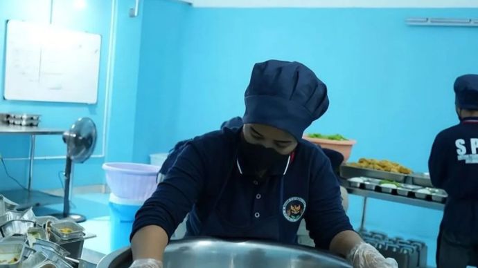 Seorang petugas SPPG tengah mendinginkan makanan usai dimasak untuk menjaga keamanan pangan Program MBG