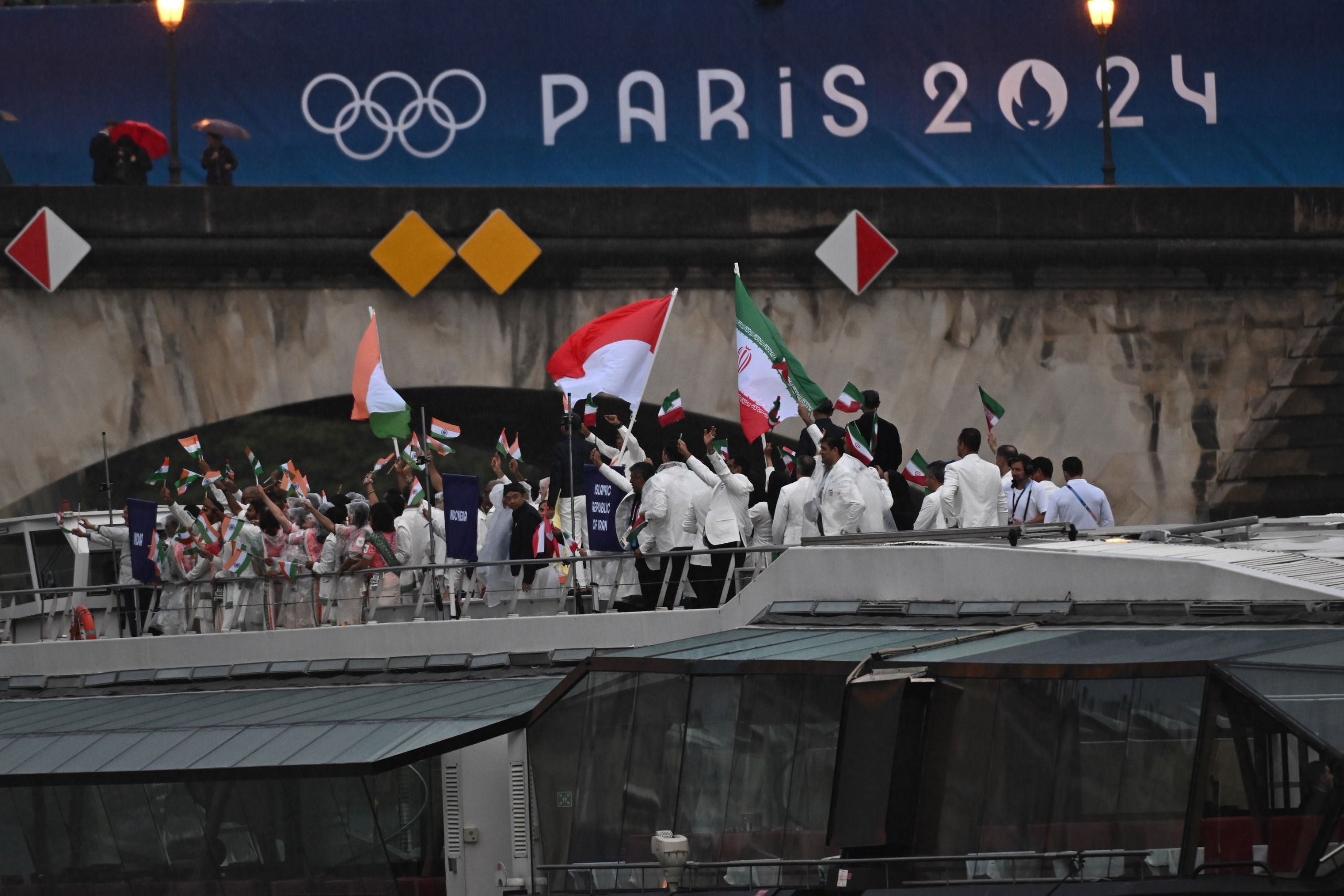 Kapal dari Kontingen Atlet Indonesia melintasi Sungai Seine, Paris, Jumat (26/7) saat Pembukaan Olimpiade ke-33. Tim kontingen Indonesia bersama dengan delegasi atlet dari Iran dan India. Dalam acara pembukaan terdapat 160 kapal yang melintasi Sungai Seine, 94 di antaranya membawa para atlet. Foto: Wahyu Putro A/ANTARA <b>(Wahyu Putro A/ANTARA)</b>