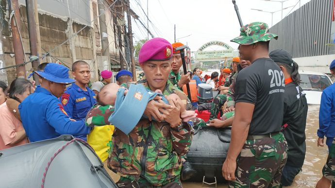 Marinir bantu evakuasi warga yang terjebak banjir.