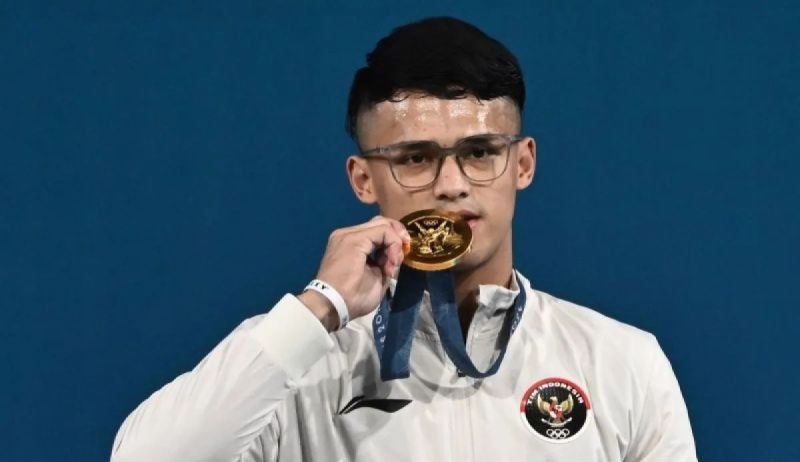 Lifter Indonesia Rizki Juniansyah berpose dengan medali emasnya usai upacara pengalungan medali kelas 73 kg putra Olimpiade Paris 2024 di South Paris Arena, Paris, Prancis, Kamis (8/8/2024).  <b>(ANTARA FOTO/Wahyu Putro A/pras.)</b>