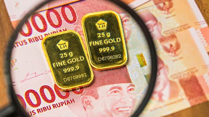 Ilustrasi - Profil Emas Murni 25 gram produksi Aneka Tambang diatas uang rupiah. 