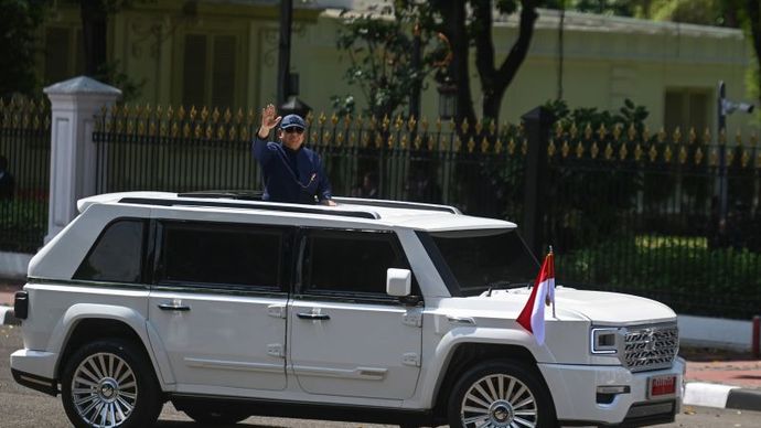 Presiden Prabowo Subianto berdiri menyapa warga dari mobil Pindad Maung Garuda saat tiba di Istana Merdeka, Jakarta, Minggu (20/10/2024). 