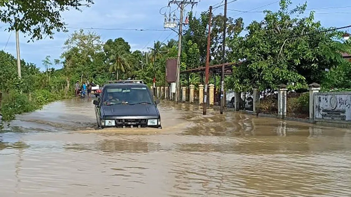 Kendaraan melintasi banjir di wilayah Kabupaten Pidie, Aceh, Sabtu (23/11/2024).