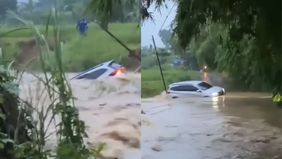 Sebuah mobil diduga berjenis Toyota Veloz, terseret banjir deras saat melintas melintasi Jalan Kertarahayu - Bondol, Kampung Nawit, Desa Kertarahayu, Kec. Setu perbatasan Setu - Serang Baru dekat Perumahan Villa Lestari Cikarang.