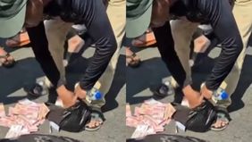 Sejumlah warga membantu mengamankan uang yang berserakan di pinggir jalan setelah pelaku perampokan Rp300 juta berhasil ditangkap di depan Bengkel Final Gear, Parung, Ciputat, Bojongsari Depok.