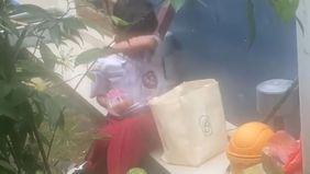 Seorang anak sekolah dasar tampak berjalan pulang sambil menenteng sebuah kantong makanan. Kantong itu berisi paket Makan Bergizi Gratis (MBG) yang ia dapatkan dari sekolahnya.