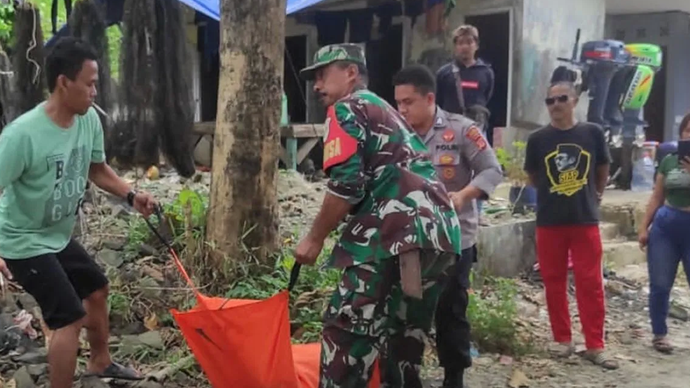 Petugas dari TNI dan Polri yang dibantu nelayan Desa Pasiripis, Kecamatan Surade, Kabupaten Sukabumi, Jabar saat mengevakuasi jasad seorang pria berkaos loreng TNI yang ditemukan mengambang di Pantai Minajaya pada Selasa, (11/2/2025).