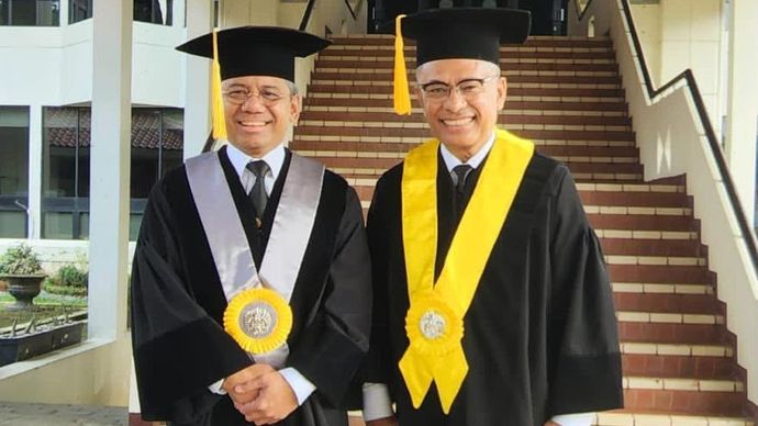 Menteri Keuangan Prof. Suahasil Nazara (kiri) bersama Wakil Ketua Umum Kadin Perindustrian Saleh Husin (kanan) saat mengenakan toga akademis Universitas Indonesia.