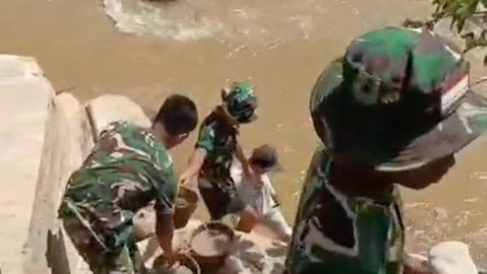 Sejumlah personel TNI tampak bahu-membahu memulai proses pembangunan jembatan pascabencana bencana di Tapanuli Tengah, Sumatra Utara