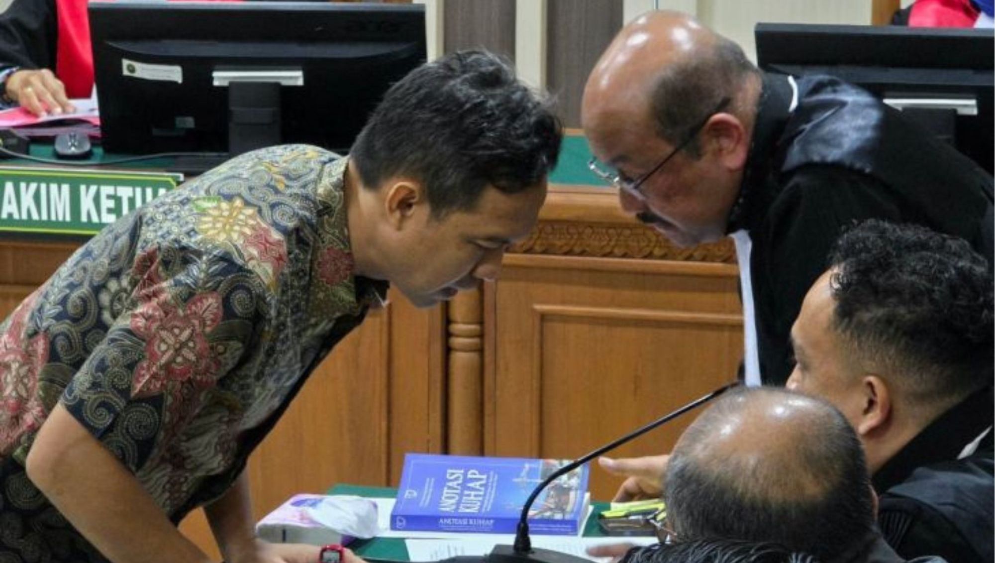 Bupati Non-aktif Cilacap Syamsul Auliya Rachman berkonsultasi dengan advokat yang medampinginya saat menjalani sidang di Pengadilan Tipikor Semarang, Jumat (31/7/2026). <b>(Antara)</b>