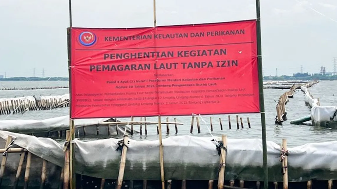Arsip Foto - Spanduk berwarna merah dari KKP bertuliskan Kementerian Kelautan dan Perikanan Penghentian Kegiatan Reklamasi Tanpa PKKPRL terpasang di pagar laut perairan Bekasi, Jawa Barat, Rabu (15/1/2025)
