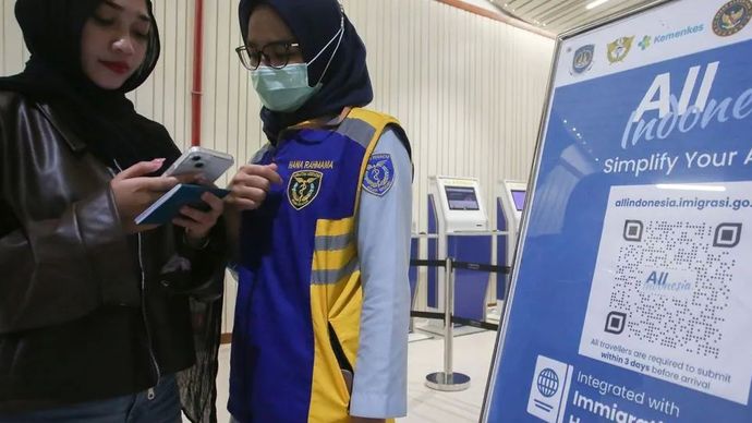 Petugas dari Balai Besar Kekarantinaan Kesehatan (BBKK) Bandara Internasional Soekarno-Hatta membantu penumpang mengisi aplikasi ALL Indonesia setibanya di Terminal 3 Bandara Soekarno Hatta, Tangerang, Banten, Jumat (30/1/2026). 