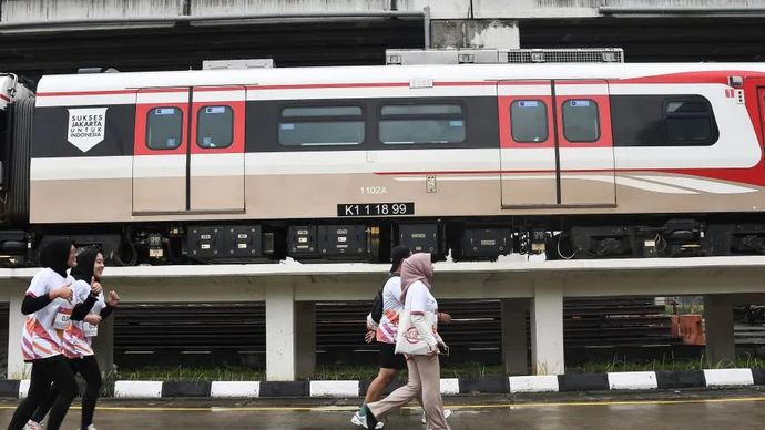 Sejumlah pelari melintas di samping rangkaian kereta LRT saat mengikuti rise up fun run di Depo LRT Jakarta di Kelapa Gading, Jakarta Utara, Minggu (8/12/2024). Fun run yang merupakan rangkaian peringatan 5 tahun perjalanan operasional LRT Jakarta itu diikuti 1.300 peserta dengan tiga kategori, yaitu masyarakat umum 5 kilometer, anak-anak dengan panjang rute 300 meter dan 1,2 kilometer. 