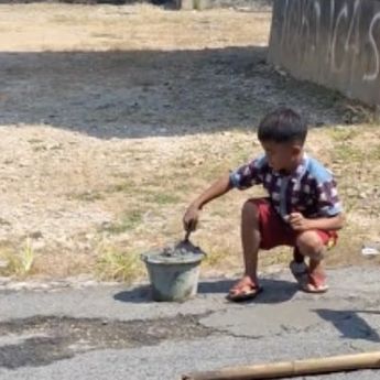 Jalan Rusak, Seorang Bocah Lakukan Aksi Heroik Tambal Jalan Sendiri