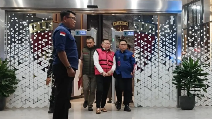 Tersangka kasus dugaan korupsi penyimpangan tata kelola izin usaha pertambangan (IUP) PT QSS di Kalimantan Barat tahun 2017&ndash;2025, SDT (tengah), digiring oleh petugas menuju mobil tahanan di Gedung Jampidsus Kejagung, Jakarta, Kamis (21/5/2026). ANTARA/Nadia Putri Rahmani