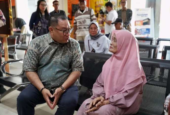 Komisaris Utama PT TASPEN Fary Djemy Francis (kiri) sedang berbincang dengan salah satu pensiunan penerima gaji ke-13 di Pos Indonesia Cabang Batam, Kepri, Rabu (3/6/2026). (ANTARA/HO-Taspen) <b>(Antara)</b>