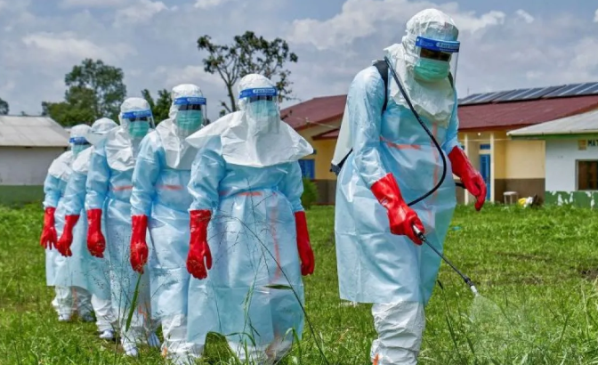 Petugas Palang Merah berjalan berbaris saat melakukan disinfeksi di Rumah Sakit Umum Rwampara sebelum menangani jenazah seorang korban yang meninggal akibat Ebola di Centre Medical Evangelique (CME), komune Hoho, Bunia, Provinsi Ituri, Republik Demok <b>(Antara)</b>