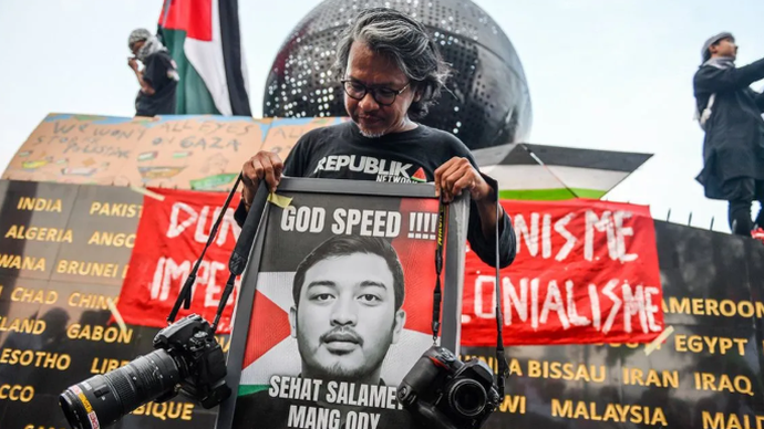 Pewarta foto senior, Yogi Ardhi memegang foto Pewarta Foto Republika Thoudy Badai salah satu jurnalis yang diculik Israel dalam misi Global Sumud Flotilla saat mengikuti aksi solidaritas bagi WNI dan Jurnalis di Jalan Asia Afrika, Bandung, Jawa Barat, Selasa (19/5/2026). ANTARA FOTO/Raisan Al Farisi/agr