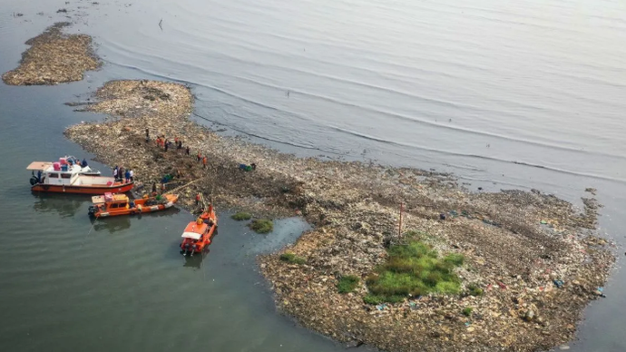 Foto udara petugas mengangkut sampah yang mengendap di perairan laut Jakarta, Rabu (3/6/2026). Petugas Suku Dinas Lingkungan Hidup Kepulauan Seribu dan Unit Penanganan Sampah Badan Air mengerahkan 20 petugas untuk membersihkan endapan sampah di hamparan sedimentasi yang merusak ekosistem laut dan mengganggu aktivitas nelayan. ANTARA FOTO/Sulthony Hasanuddin/nz (ANTARA FOTO/SULTHONY HASANUDDIN)