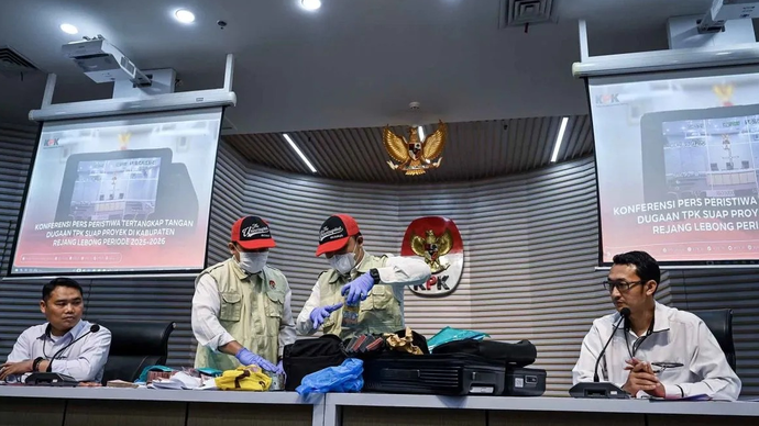 Penyidik KPK menunjukkan koper berisi barang bukti uang tunai dalam Operasi Tangkap Tangan (OTT) tindak pidana korupsi suap ijon proyek di Bengkulu tahun 2025-2026 yang disaksikan Deputi penindakan dan Eksekusi KPK Asep Guntur Rahayu (kiri) dan Juru 