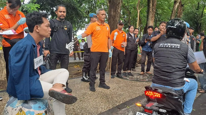 Tersangka kasus pelecehan seksual berinisial IWAS (kiri) duduk di atas bola semen pembatas jalan saat memerankan salah satu adegan rekonstruksi yang berlangsung di kawasan Taman Udayana, Mataram, NTB, Rabu (11/12/2024).