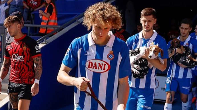 Para pemain Espanyol masuk ke lapangan dengan membawa anjing