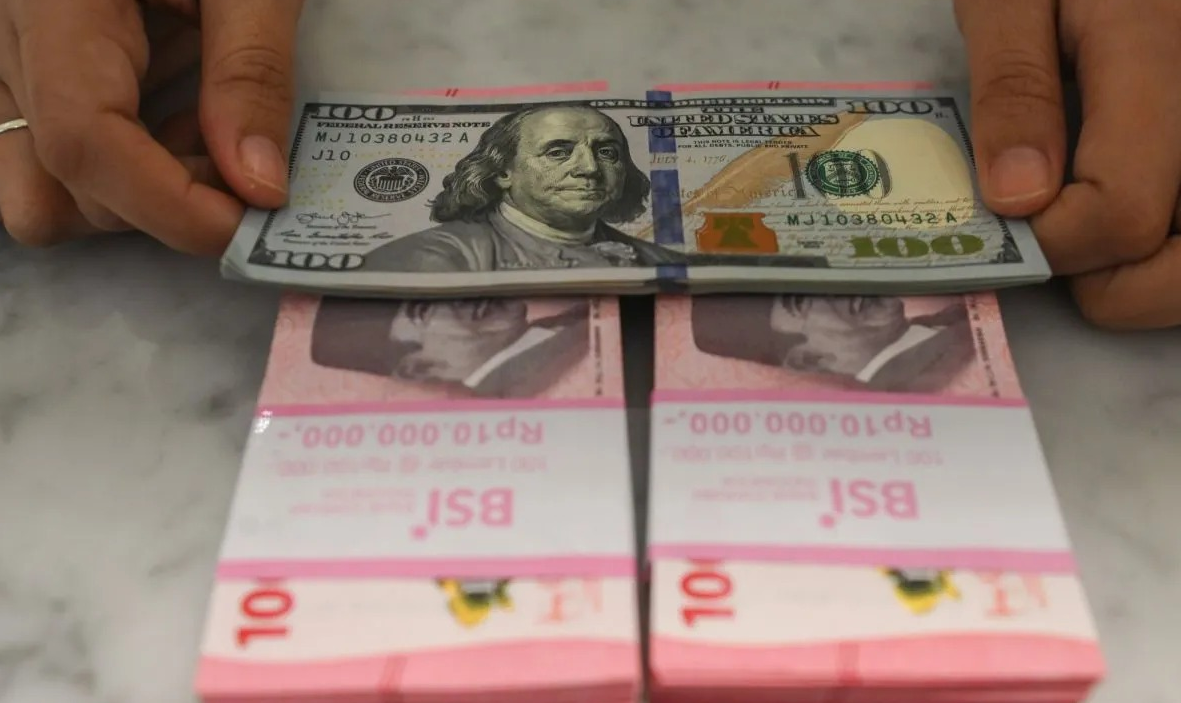 Pegawai menunjukkan uang rupiah dan dolar AS di Bank Syariah Indonesia, Tangerang Selatan, Banten. ANTARA FOTO/Hafidz Mubarak A/wsj. <b>(Antara)</b>