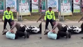 Viral video memperlihatkan seorang polisi mencoba menghentikan pengendara motor yang melanggar aturan lalu lintas dan kedua belah pihak terjatuh.